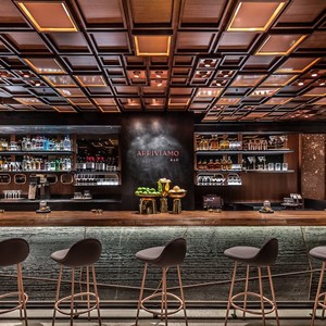 The custom walnut ceiling frames this bar perfectly