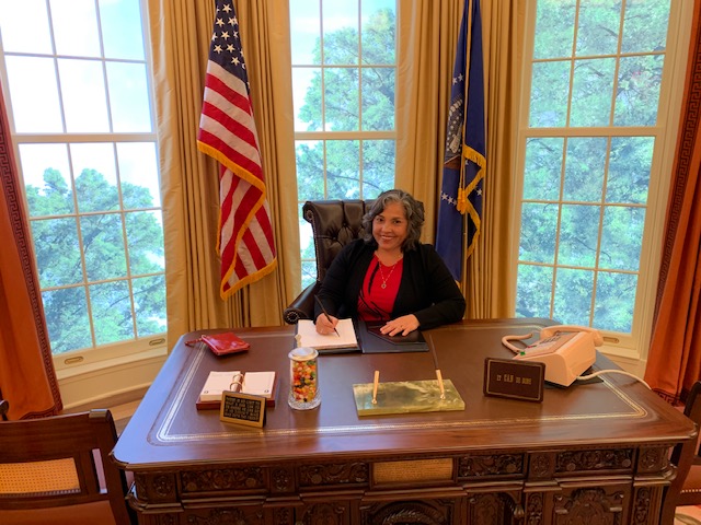 Teresa Richey at the Resolute desk at the opening of the exhibit 2020