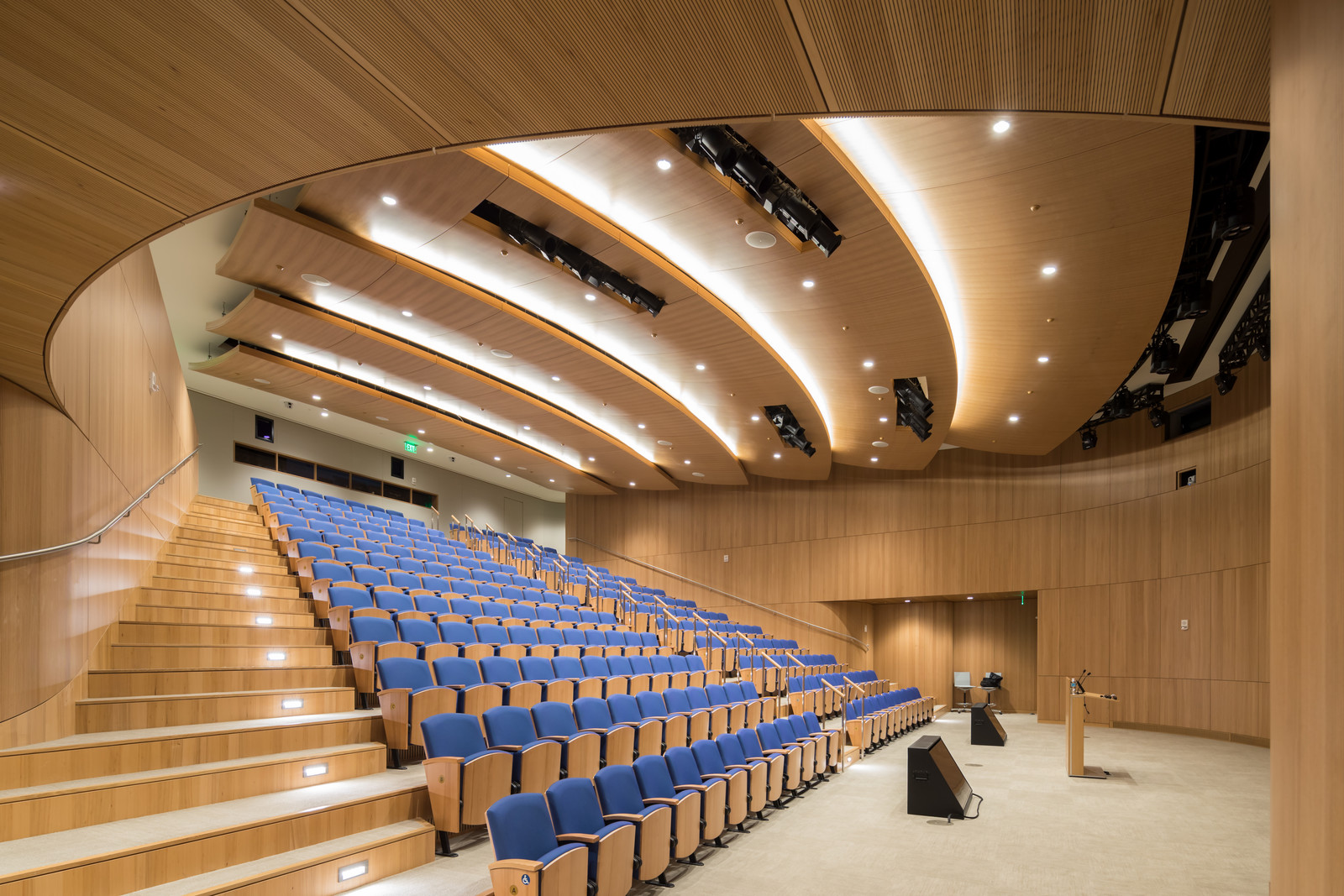 This beautiful auditorium features curved acoustic paneling of quartered Elm. The ceiling was very technical although it is made to look like light layers of clouds. Extensive modeling was essential to meet the acoustic requirement and to coordinate the complex mechanical, electrical and AV specifications